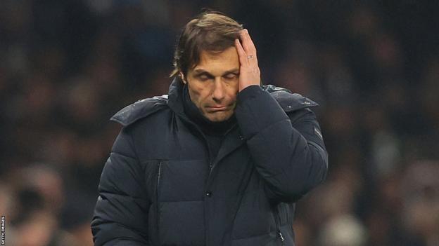 Antonio Conte puts his hand to his head during a match