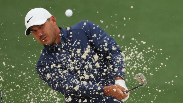 Brooks Koepka splashes out of the sand at the Masters
