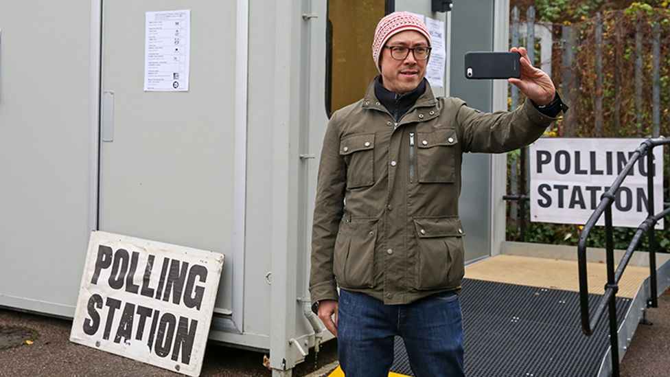 A person takes a selfie at a polling station in London in 2019