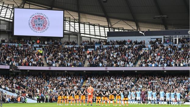 Manchester City and Leeds players observe the national anthem at Etihad Stadium on Saturday